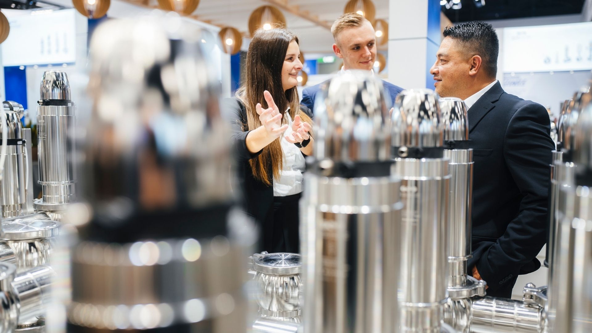 Zwei Messebesucher betrachten ein Bierglas